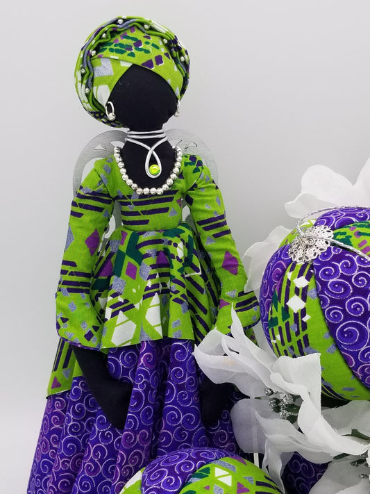 african american christmas angle in lime green and purple jewel tones african print fabric and silver jewelry earrings, necklace, and chocker, and wooden wings with colorful rhinestones.