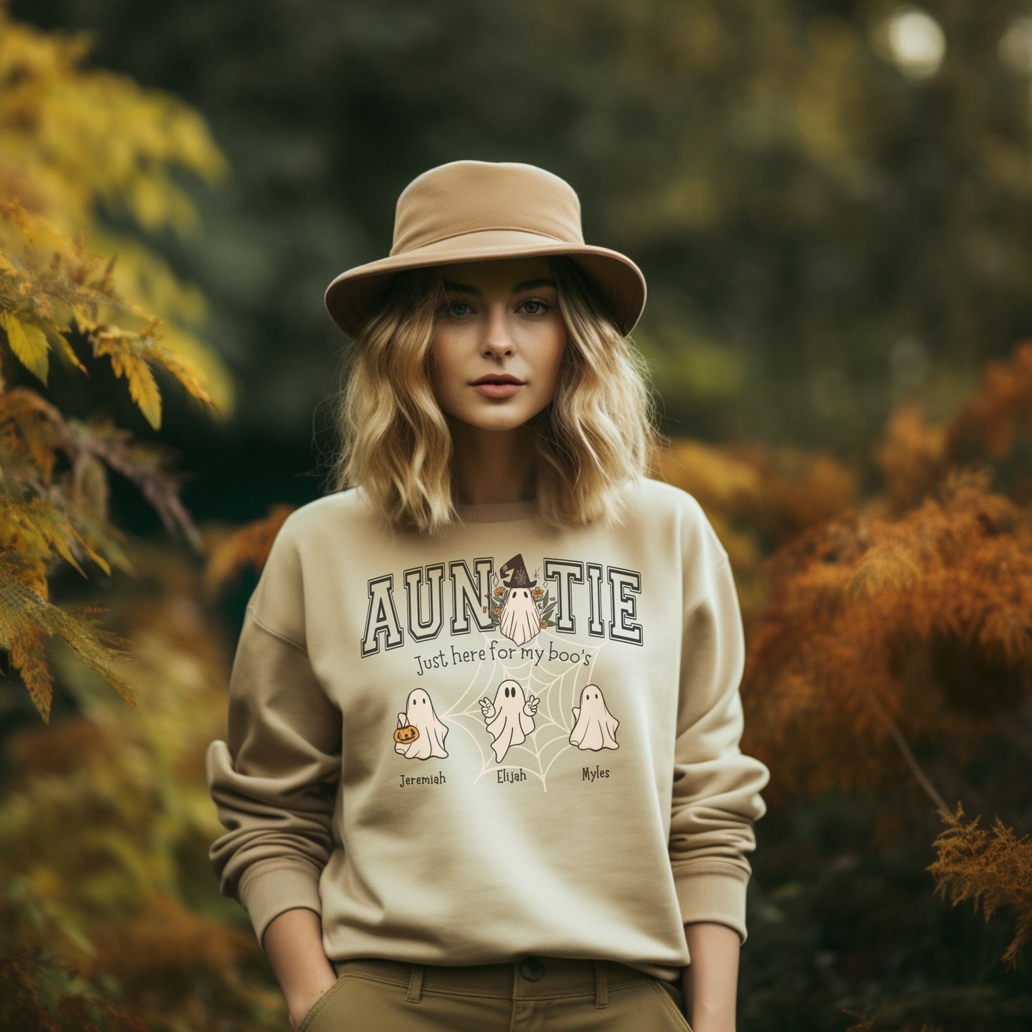 young women wearing a sand color halloween ghost shirt with the word auntie and several small ghosts personalized with names under them.